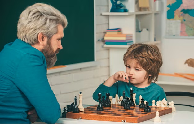 Ben teaching a student chess over a board